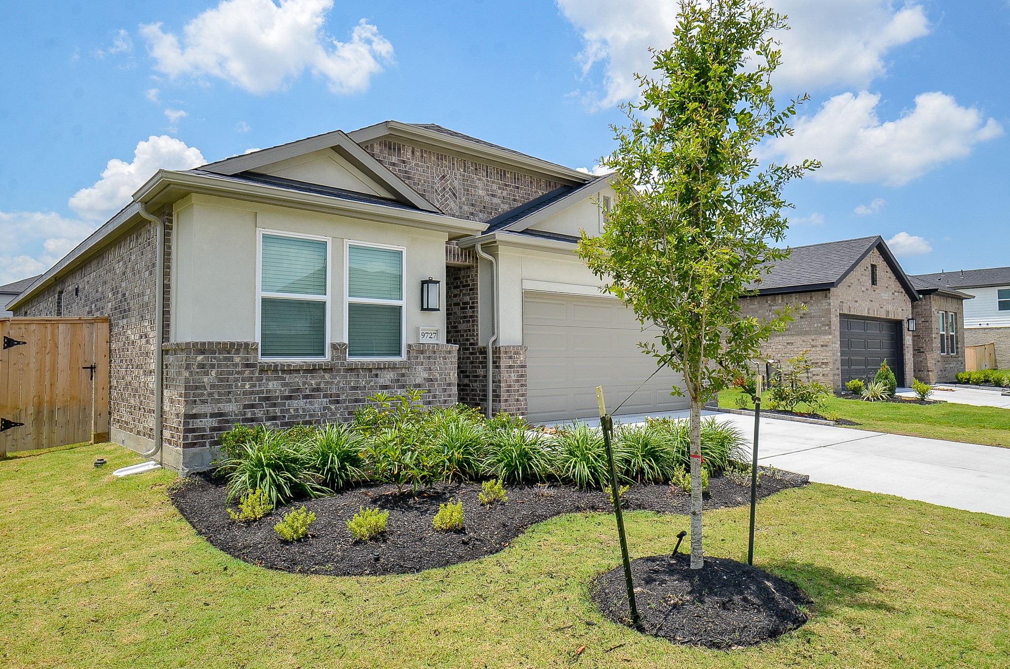 9727 Rialto Hts Drive Cypress, TX 77433 - Photo 2 of 37 This modern single-story home features a brick and stucco exterior with a spacious two-car garage. The well-maintained front yard includes a neatly landscaped garden, creating an inviting curb appeal.