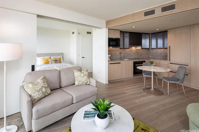 a living room with furniture kitchen and a wooden floor