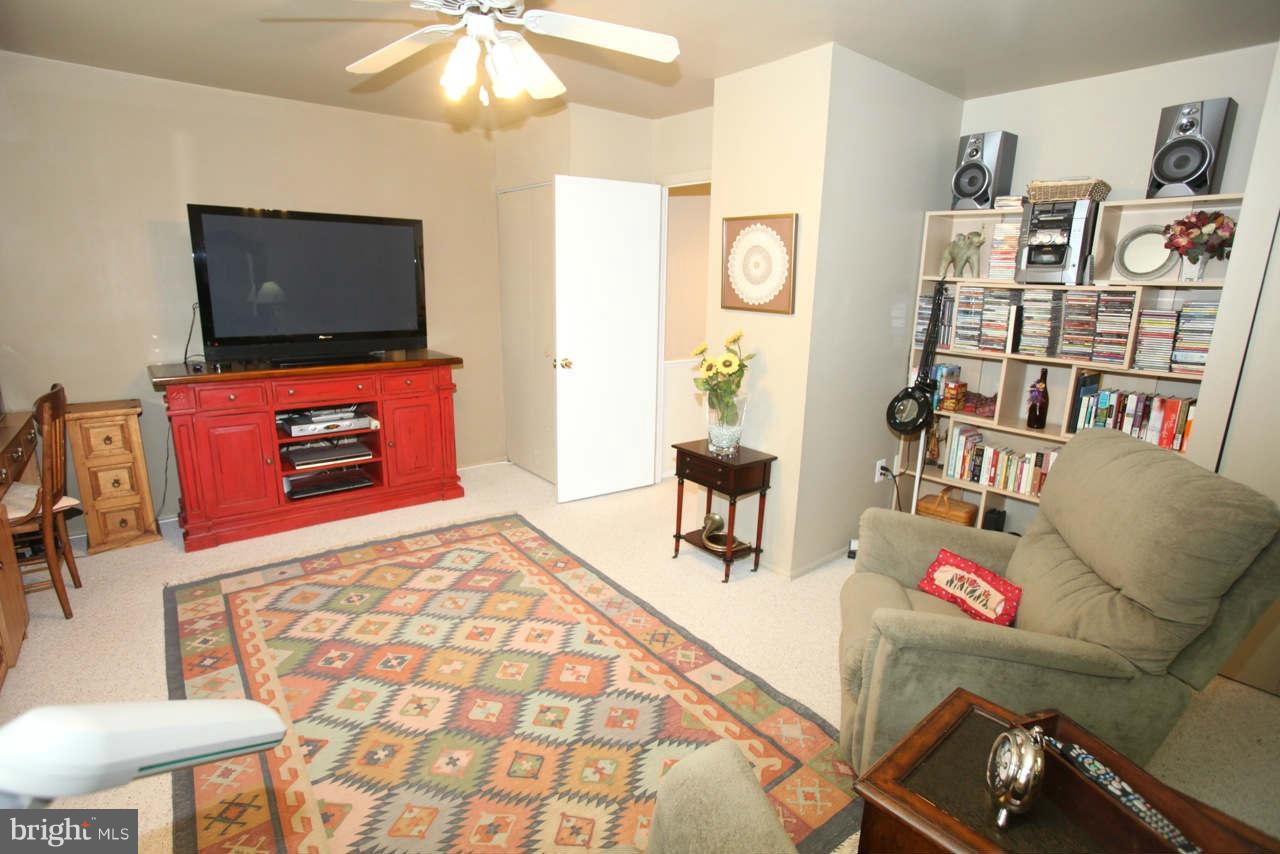14 Stone Ridge Court, Unit 25 Baltimore, MD 21239 - Photo 11 of 30 a living room with a couch and a flat screen tv