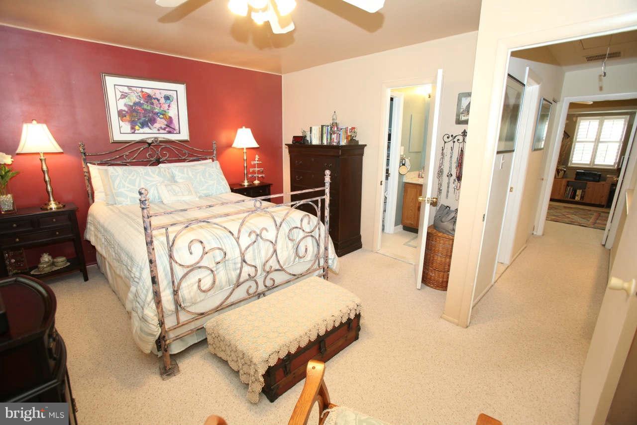 14 Stone Ridge Court, Unit 25 Baltimore, MD 21239 - Photo 16 of 30 a bedroom with a bed and a chandelier