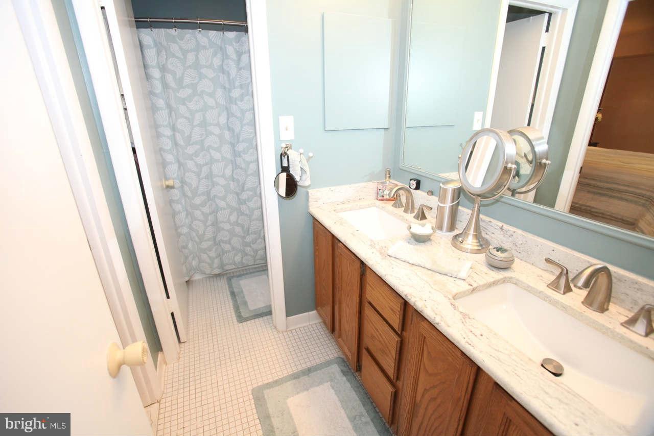 14 Stone Ridge Court, Unit 25 Baltimore, MD 21239 - Photo 18 of 30 a bathroom with a sink a mirror and vanity