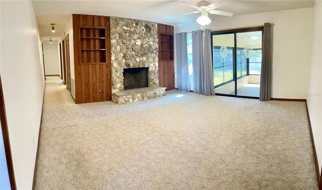 a view of an empty room with a fireplace and a window