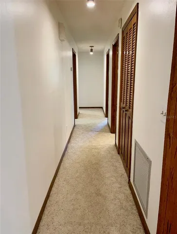 a view of a hallway with wooden floor