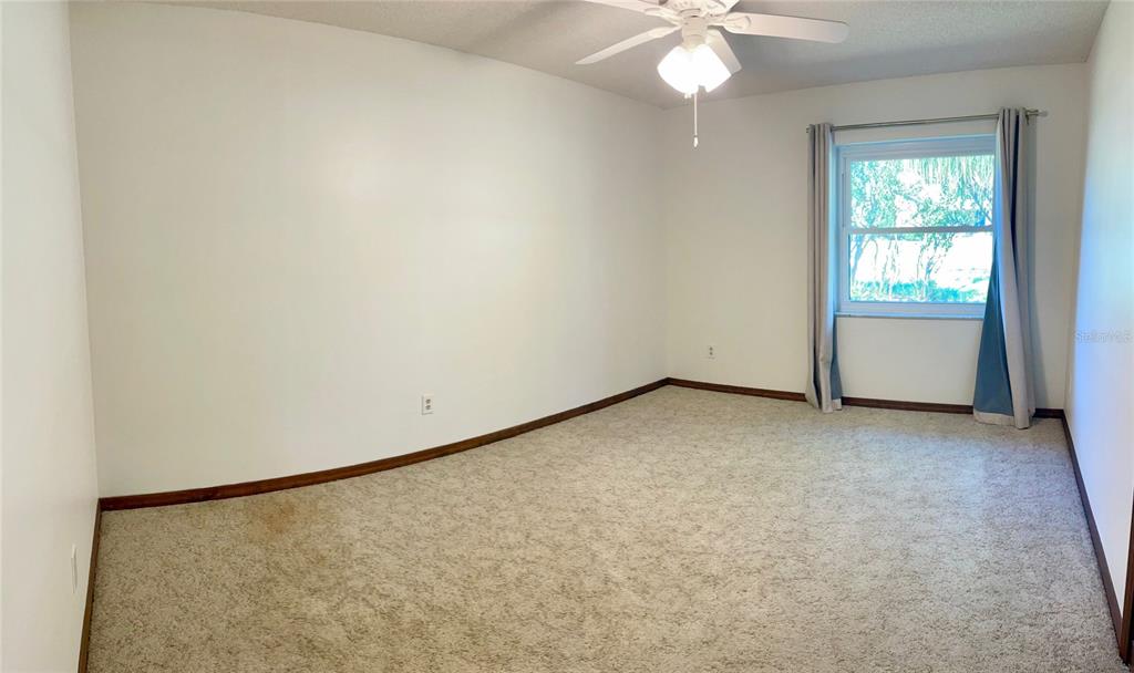 4524 Southeast 11th Place Ocala, FL 34471 - Photo 14 of 31 an empty room with a chandelier fan and windows