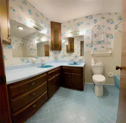 a bathroom with a granite countertop toilet sink and mirror