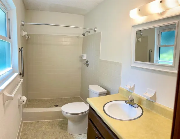 a bathroom with a sink a toilet and shower