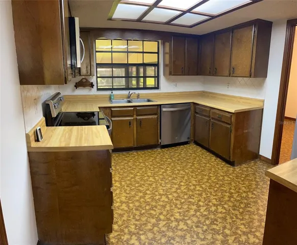 a kitchen with stainless steel appliances a stove a sink and a microwave