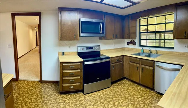 a kitchen with a cabinets appliances and a window