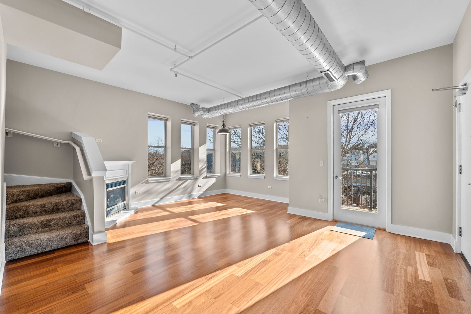 351 Front Street, Unit 2212 Lemont, IL 60439 - Photo 10 of 36 a view of an empty room with wooden floor and stairs