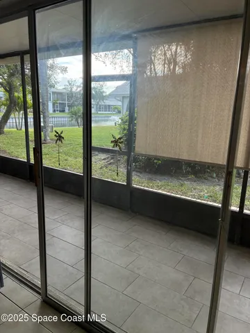 a view of a house with a yard and a large tree