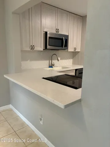 a kitchen with granite countertop a stove a sink and a microwave
