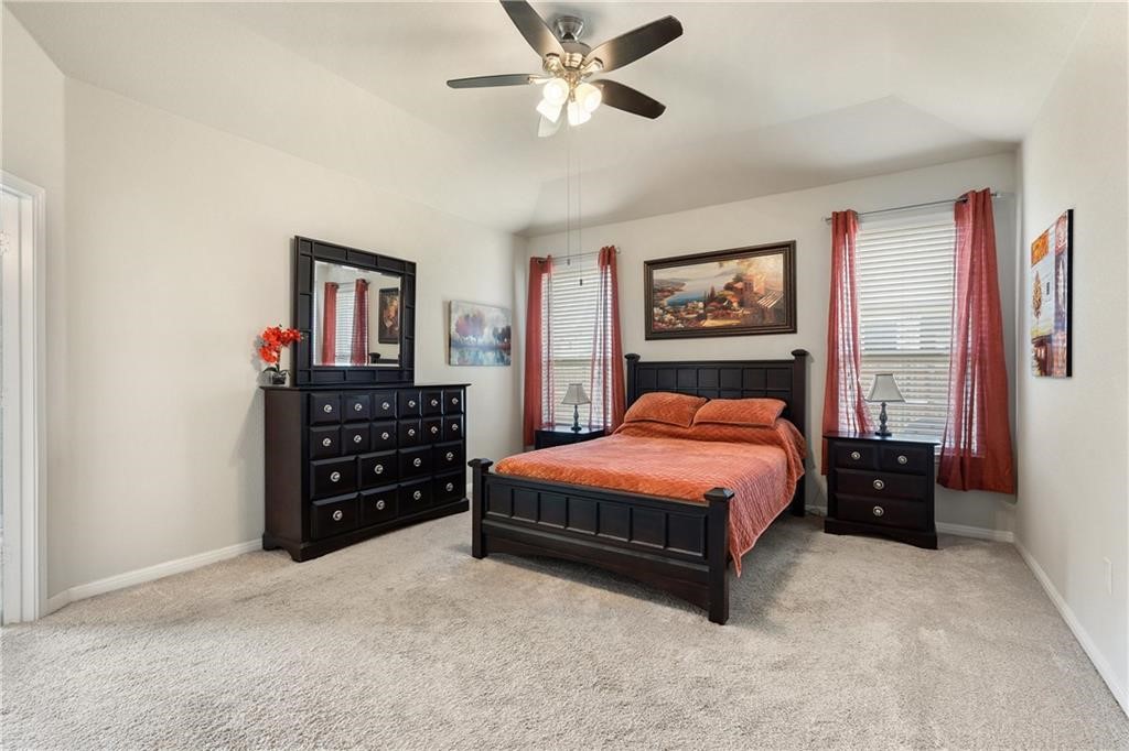 601 Flag Lane Leander, TX 78641 - Photo 16 of 38 a spacious bedroom with a bed a dresser and a large window