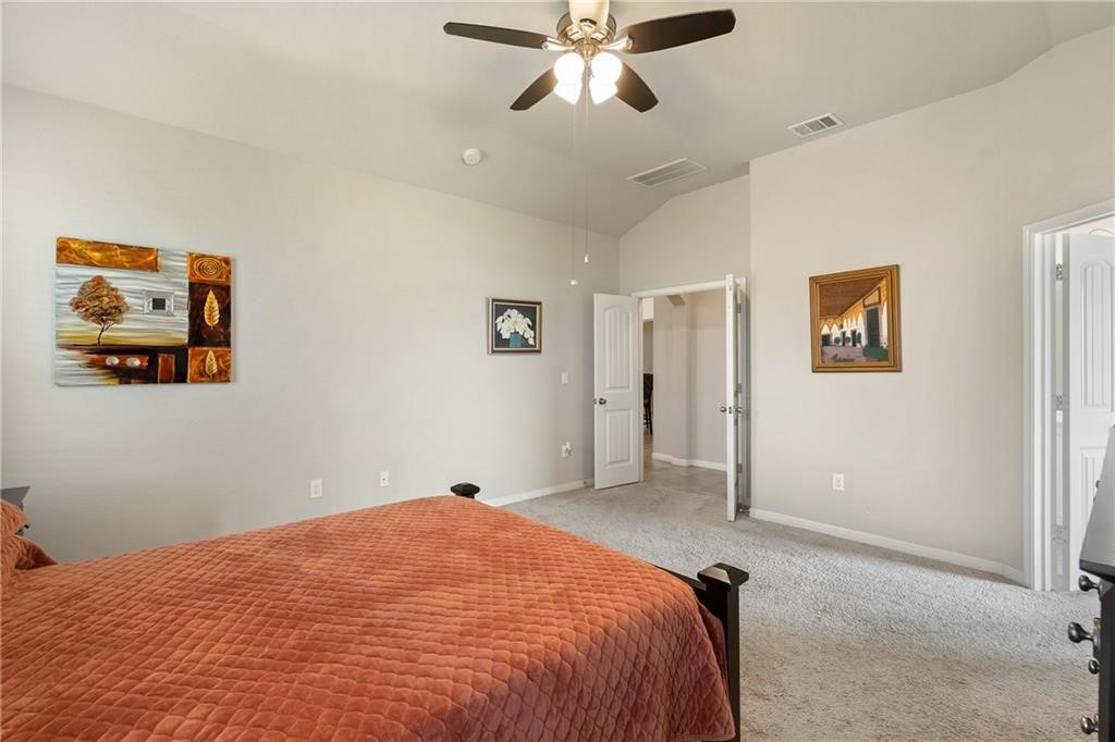 601 Flag Lane Leander, TX 78641 - Photo 17 of 38 a bedroom with a large bed and a chandelier
