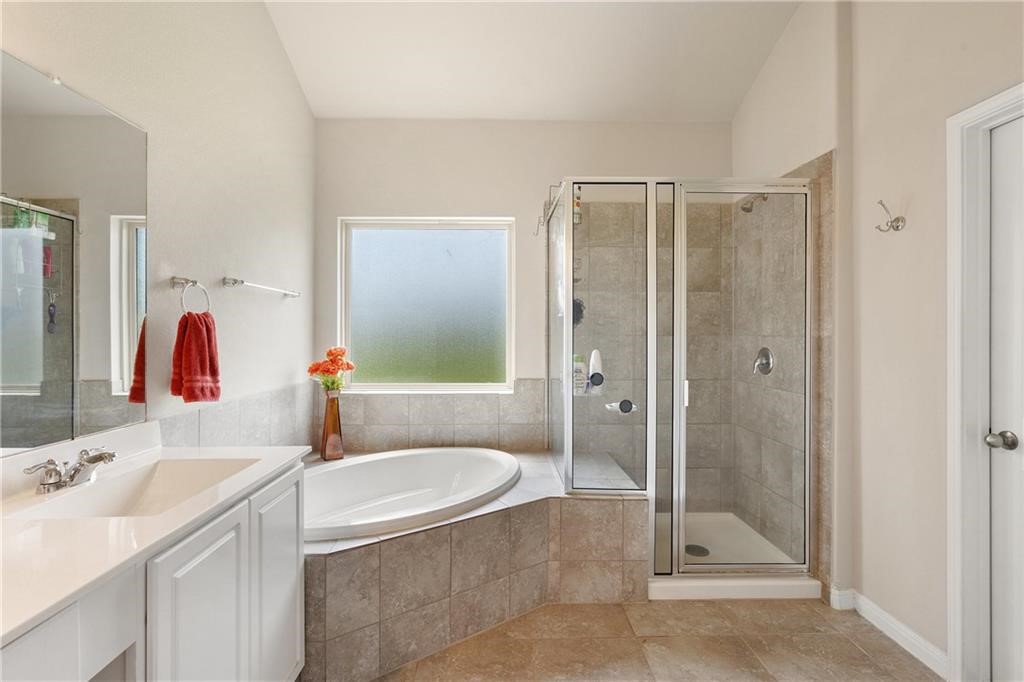 601 Flag Lane Leander, TX 78641 - Photo 18 of 38 a bathroom with a tub sink shower and mirror