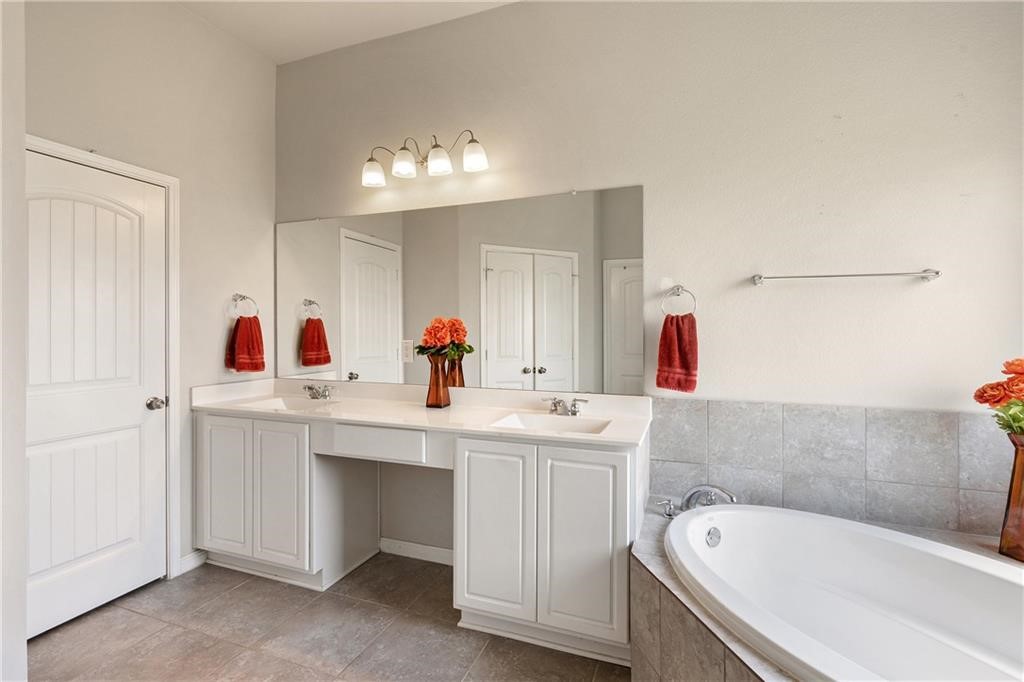 601 Flag Lane Leander, TX 78641 - Photo 20 of 38 a bathroom with a tub sink and mirror