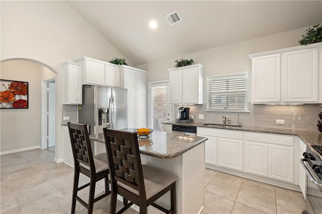 601 Flag Lane Leander, TX 78641 - Photo 24 of 38 a kitchen with a table chairs refrigerator and cabinets