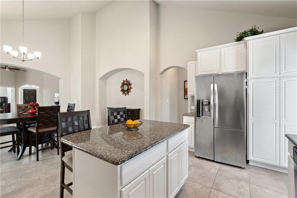 601 Flag Lane Leander, TX 78641 - Photo 25 of 38 a kitchen with stainless steel appliances granite countertop a table chairs and a refrigerator