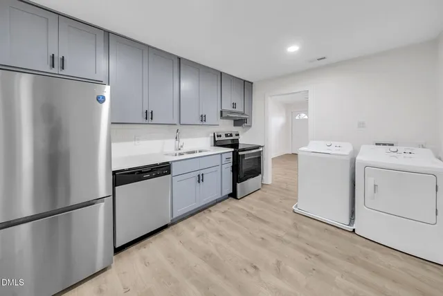 a kitchen with a refrigerator sink stove and cabinets