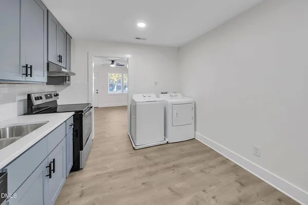 a utility room with cabinets washer and dryer