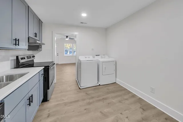 a utility room with cabinets washer and dryer