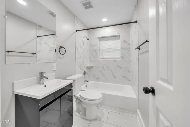 a bathroom with a bathtub shower sink vanity and a toilet