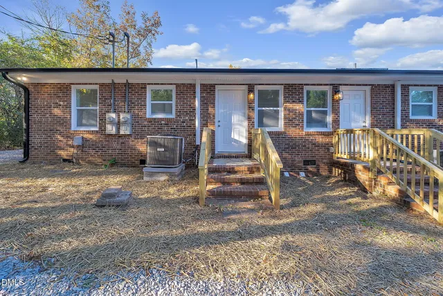 a backyard of a house with barbeque oven table and chairs