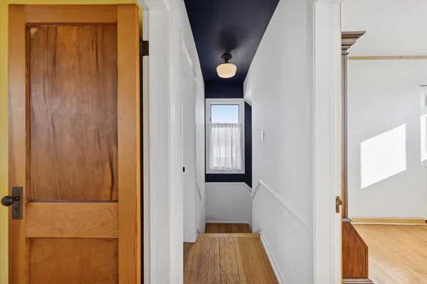 a view of a hallway with wooden floor and entryway