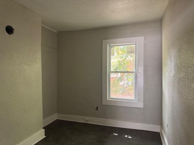 1559 Harrison Street Memphis, TN 38108 - Photo 6 of 11 Empty room with a textured wall and a textured ceiling