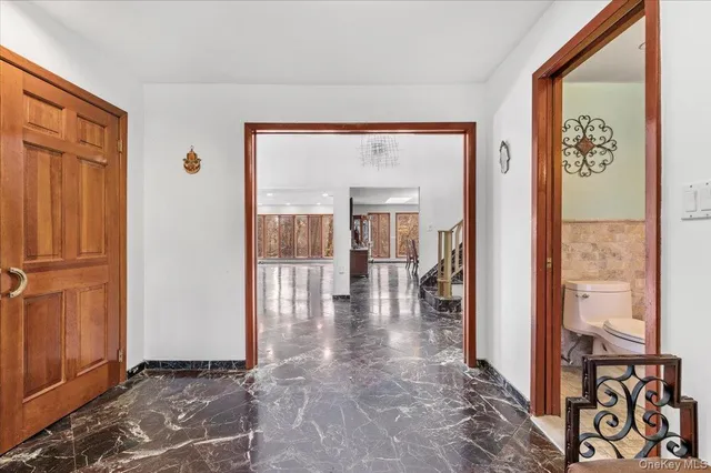 a view of a hallway with wooden floor and a dining room