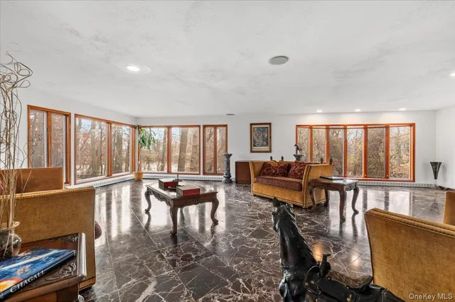a living room with furniture and floor to ceiling windows