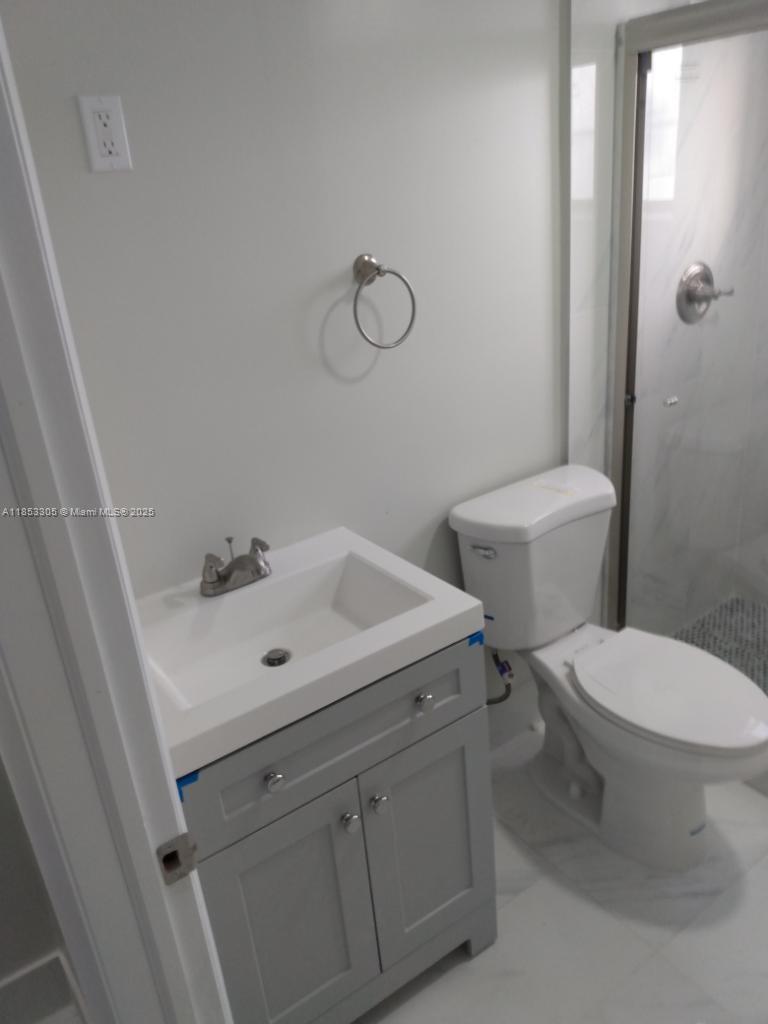 1331 Southwest 124th Court, Unit E3 Miami, FL 33184 - Photo 12 of 17 a white toilet sitting next to a bathroom sink