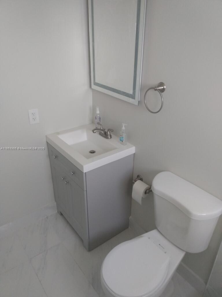 1331 Southwest 124th Court, Unit E3 Miami, FL 33184 - Photo 13 of 17 a white toilet sitting next to a bathroom sink