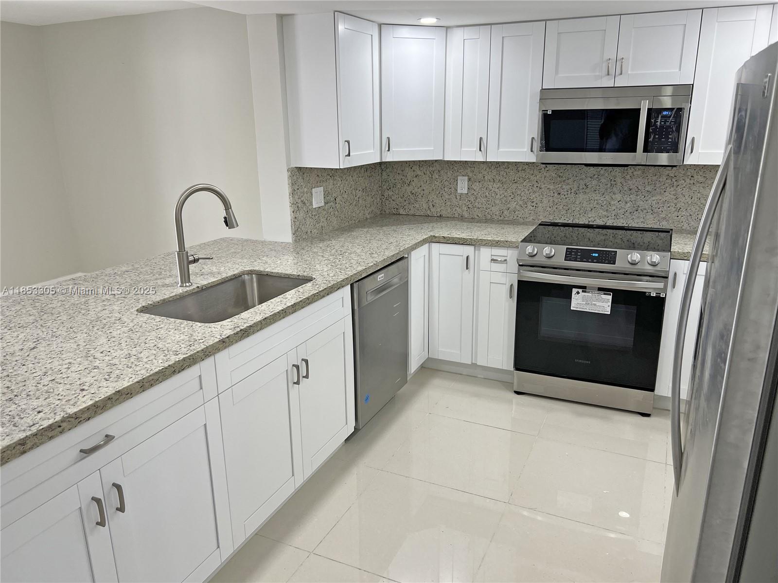 1331 Southwest 124th Court, Unit E3 Miami, FL 33184 - Photo 5 of 17 a kitchen with stainless steel appliances granite countertop a sink and a stove