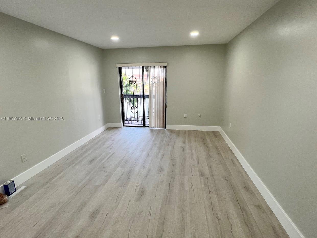 1331 Southwest 124th Court, Unit E3 Miami, FL 33184 - Photo 7 of 17 wooden floor in an empty room with a window