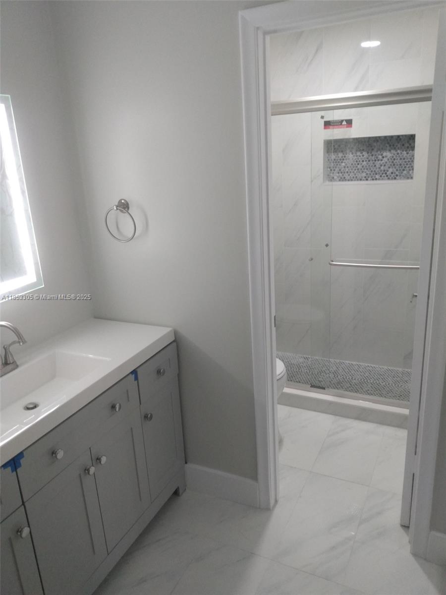 1331 Southwest 124th Court, Unit E3 Miami, FL 33184 - Photo 8 of 17 a bathroom with a granite countertop sink mirror and vanity