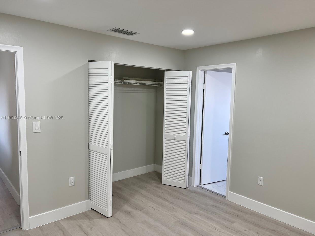 1331 Southwest 124th Court, Unit E3 Miami, FL 33184 - Photo 9 of 17 an empty room with wooden floor & closet area
