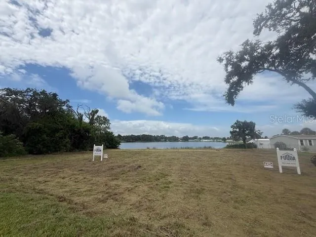 a view of a lake with houses in back