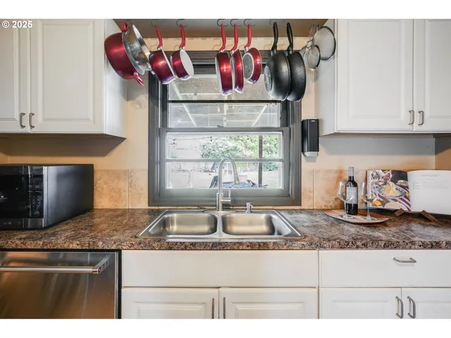 a kitchen with kitchen island granite countertop a sink a stove and cabinets