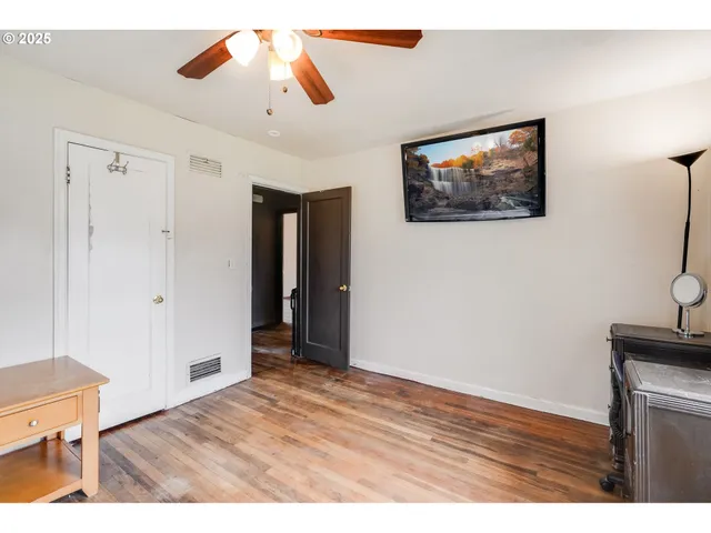 a view of an empty room with wooden floor