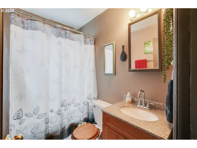 a bathroom with a granite countertop sink mirror and a shower