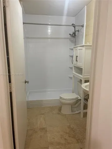 a bathroom with a toilet and a shower