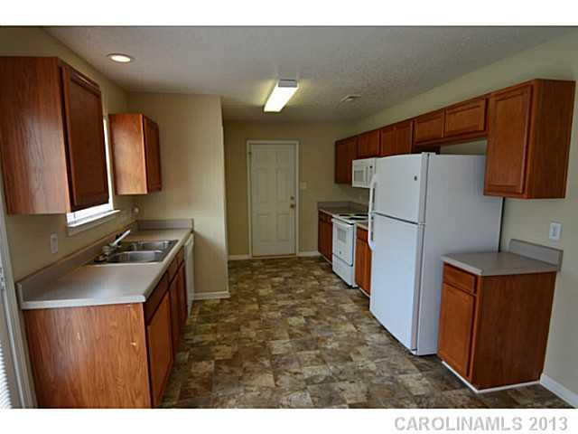 6515 Sunman Road Charlotte, NC 28216 - Photo 7 of 8 a kitchen with refrigerator and cabinets