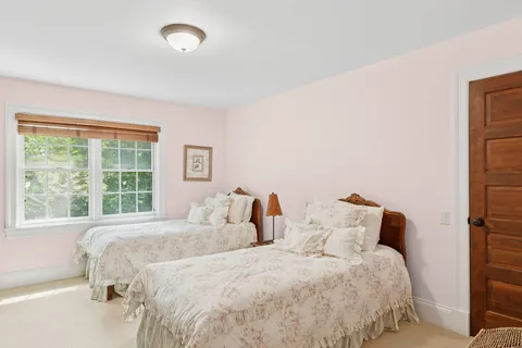 a bedroom with two beds and a large window