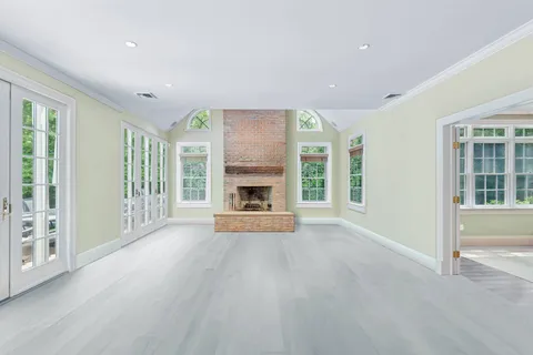 a view of an empty room with a fireplace and a window