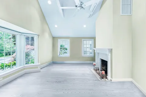 a view of an empty room with kitchen and a window