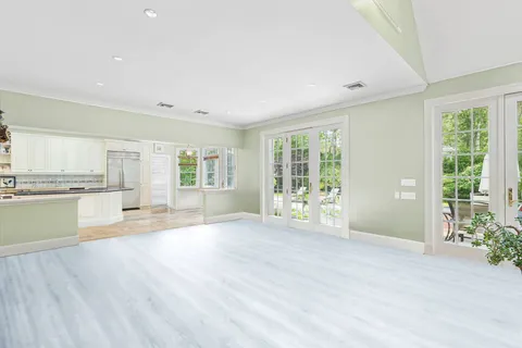 a large kitchen with kitchen island granite countertop a large window and white stainless steel appliances