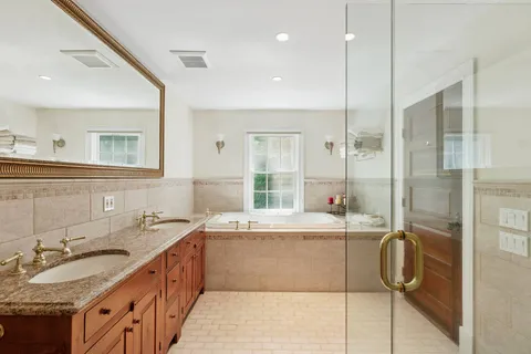 a bathroom with a tub sink and mirror