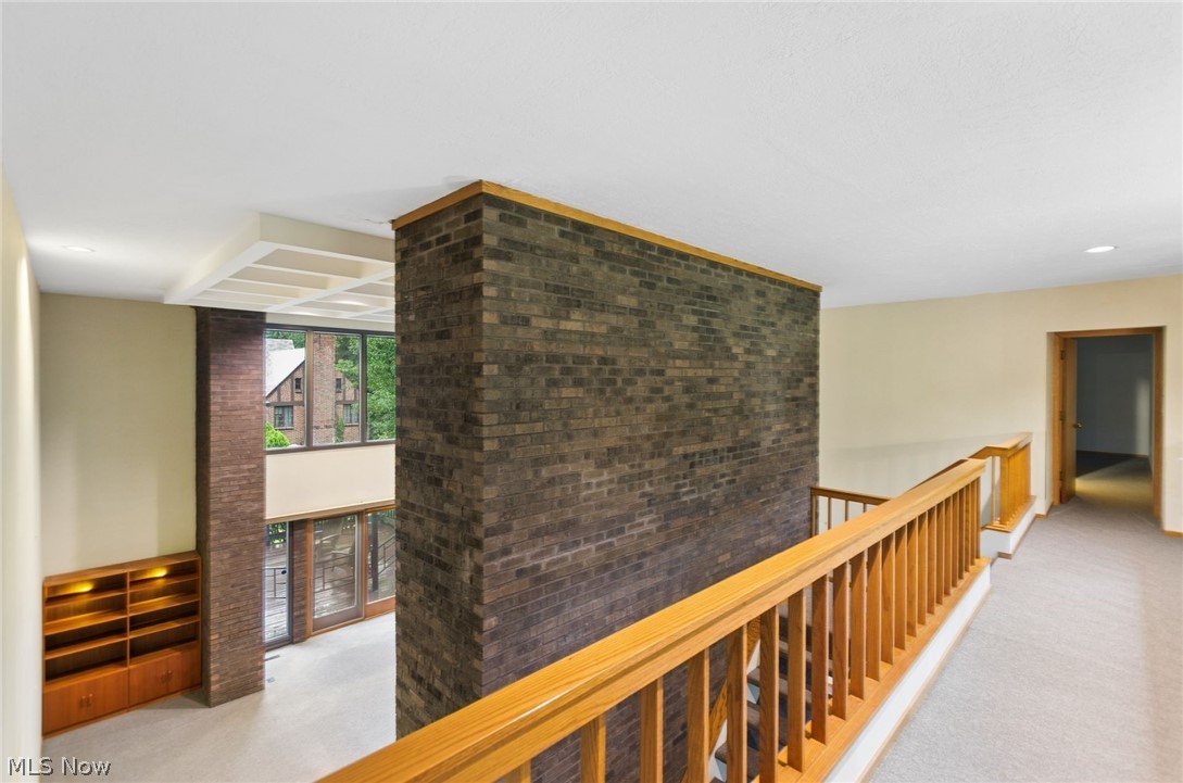 200 Hampshire Road Akron, OH 44313 - Photo 24 of 50 Upper-level landing with light wood-finish railings, textured brick accent wall, and built-in shelving with integrated lighting