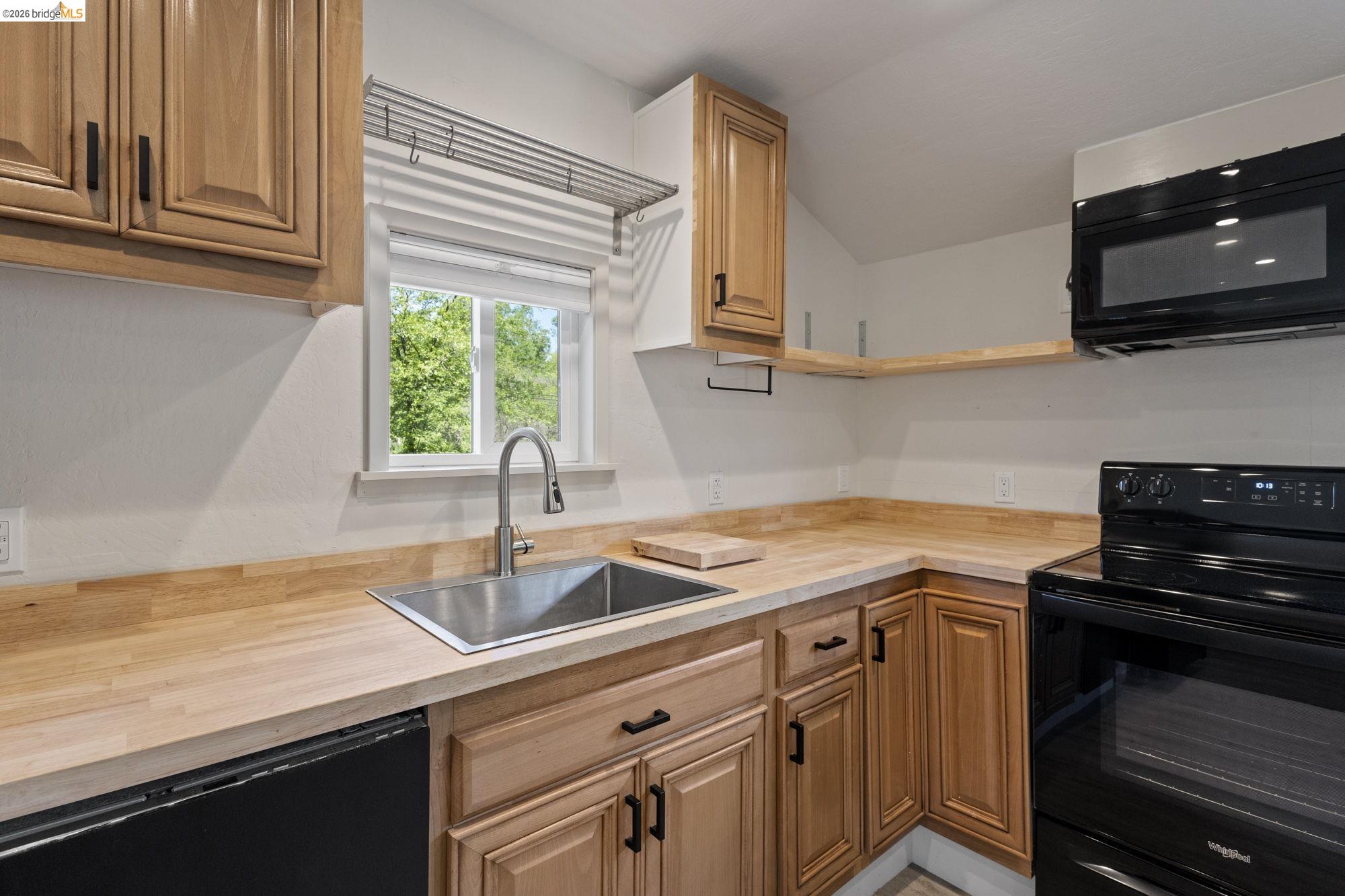18363 Yosemite Road Tuolumne, CA 95379 - Photo 21 of 34 Kitchen featuring natural wood cabinetry and a stainless steel sink with a gooseneck faucet