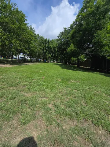a view of a field of grass and trees